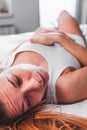 Young woman lying down in pain on the bed Royalty Free Stock Photo