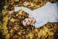 Young Woman Lying Down On Yellow Leaves, Smiling happy womanl portrait, view from above Royalty Free Stock Photo