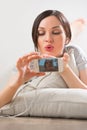 Young woman lying on the floor with her phone taking pictures Royalty Free Stock Photo