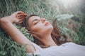 Young woman lying on the grass. Beauty woman lying on the field and looking on camera. Beautiful brunette Girl lying on the meadow Royalty Free Stock Photo