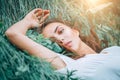 Young woman lying on the grass. Beauty woman lying on the field and looking on camera. Beautiful brunette Girl lying on the meadow Royalty Free Stock Photo