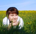 The young woman is lying on a grass on the field