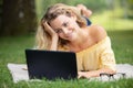 young woman lying on grass in park working on laptop Royalty Free Stock Photo