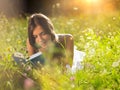 Young woman lying in meadow reading book Royalty Free Stock Photo