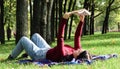 Young woman lying and reading her favorite book on a woolen plaid blanket in a city park on green grass on a pleasant sunny day. Royalty Free Stock Photo