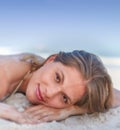 Young woman lying on sand at beach. A beautiful, young woman relaxing at the beach. Royalty Free Stock Photo