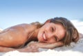 Young woman lying on sand at beach. A beautiful, young woman relaxing at the beach. Royalty Free Stock Photo