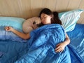 Young woman is lying and sleeping with pug dog in bed Royalty Free Stock Photo