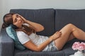 Young woman lying on the sofa in the headphones with her eyes closed relaxing, listening to calm music Royalty Free Stock Photo