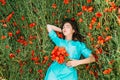 Young woman lying on summer poppy meadow.