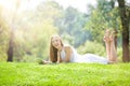 Young Woman Lying with Tablet on the Beautiful Green Meadow Royalty Free Stock Photo