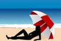 Young woman lying under an umbrella on the beach