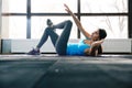 Young woman lying on the yoga mat and doing exercise Royalty Free Stock Photo