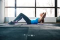 Young woman lying on the yoga mat and doing fitness exercise Royalty Free Stock Photo