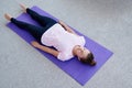 Young woman lying on yoga mat with eyes closed in savasana pose at home. Fitness, sport and healthy lifestyle concept. Corpse pose Royalty Free Stock Photo