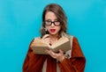 Young woman with magnifier and books