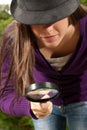Young woman with magnifier glass and hat looking