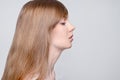 Young woman with make-up poses in studio, profile