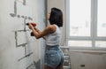 A young woman makes apartment renovations. Apartment renovation concept. Strong independent woman