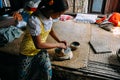 Young woman makes cosmetic paste from ground bark in a small village near Bagan.