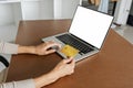 Young woman makes a purchase on the Internet on the laptop with credit card Royalty Free Stock Photo