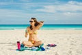 Young woman in a swimsuit in the sand makes selfie on the beach on her smartphone Royalty Free Stock Photo