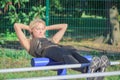 young woman makes sport exercises on the sport ground, blurred background