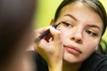 A young woman makes up in the morning, looks in the mirror, paints her eyes with black eyeliner.Charming young teenage girl paints Royalty Free Stock Photo