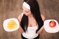 Young woman making choice between healthy and harmful food Royalty Free Stock Photo