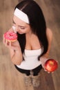 Young woman making choice between healthy and harmful food Royalty Free Stock Photo