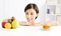 Young woman making choice between healthy and harmful food Royalty Free Stock Photo