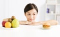 Young woman making choice between healthy and harmful food Royalty Free Stock Photo