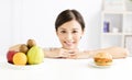 Young woman making choice between healthy and harmful food Royalty Free Stock Photo