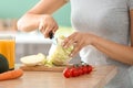 Young woman making fresh vegetable salad in kitchen, closeup Royalty Free Stock Photo