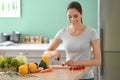 Young woman making fresh vegetable salad in kitchen Royalty Free Stock Photo