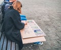 Young woman making a handmade poster as a call for action during a protest march against climate change