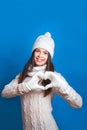 Young woman making heart shape with hands. Love winter. Royalty Free Stock Photo