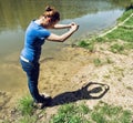 Young woman making heart shape with her hands by the lake