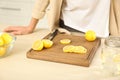 Young woman making lemon water in kitchen