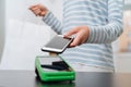 Young woman making mobile payment with her smartphone in shop Royalty Free Stock Photo