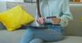 Young woman is making online payment holding bank card using modern PC Tablet at home sitting on sofa and smiling Royalty Free Stock Photo