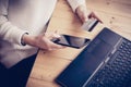 Young woman making online shopping by laptop and smartphone at working place.Girl touching home button on mobile phone Royalty Free Stock Photo