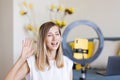 Young woman making photo or video content for social media with smartphone and light of ring lamp. Beauty blogger smiles Royalty Free Stock Photo