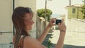 Young woman making photos of old Mediterranean town street with her smartphone Royalty Free Stock Photo