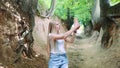 Blonde young woman making photos on smartphone in magical Roots Gorge Royalty Free Stock Photo