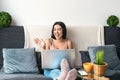 Young woman making video call sitting on sofa - Happy girl having fun doing video conference with family and friends Royalty Free Stock Photo