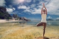 Young woman making yoga tree pose over beach Royalty Free Stock Photo