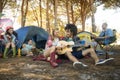 Young woman with male friend playing guitar at campsite Royalty Free Stock Photo