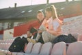 Young woman and man are chatting while sitting on the grandstand after a training at the stadium. Sport, athletics, athletes Royalty Free Stock Photo