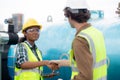 Young woman and man engineer doing agreement and handshake in the factory.